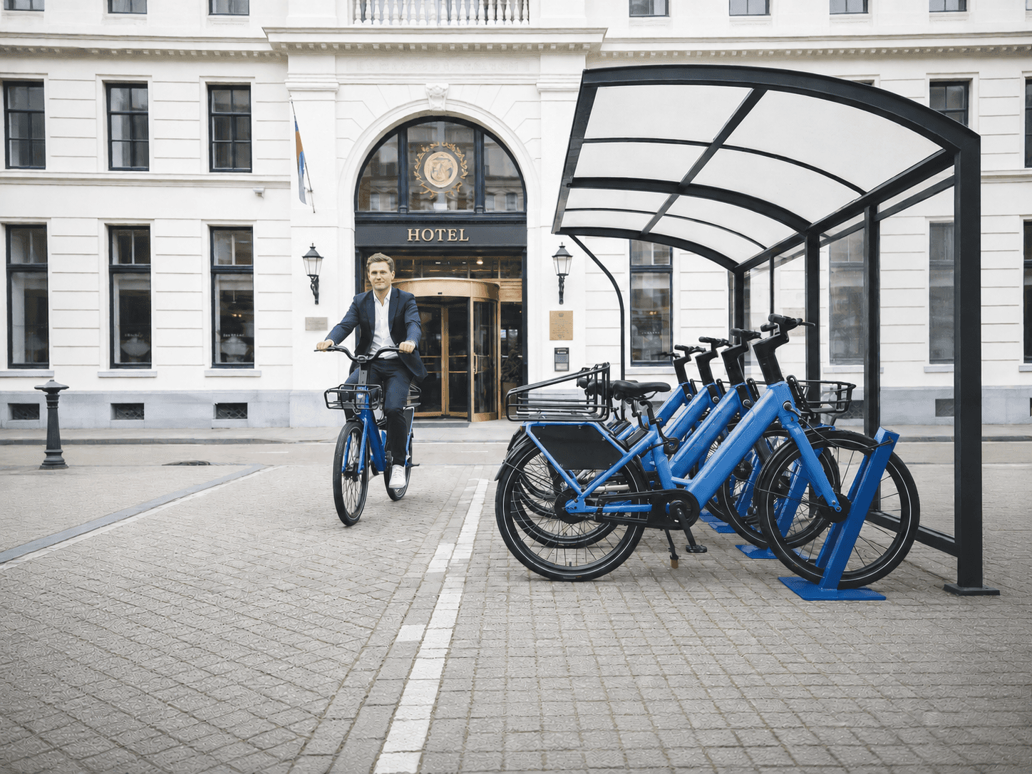Branded e-bike docking shelter at a hotel entrance with shared e-bikes ready for guests