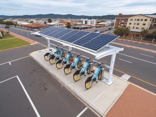 Solar-powered charging station with shared electric bikes parked under photovoltaic canopy