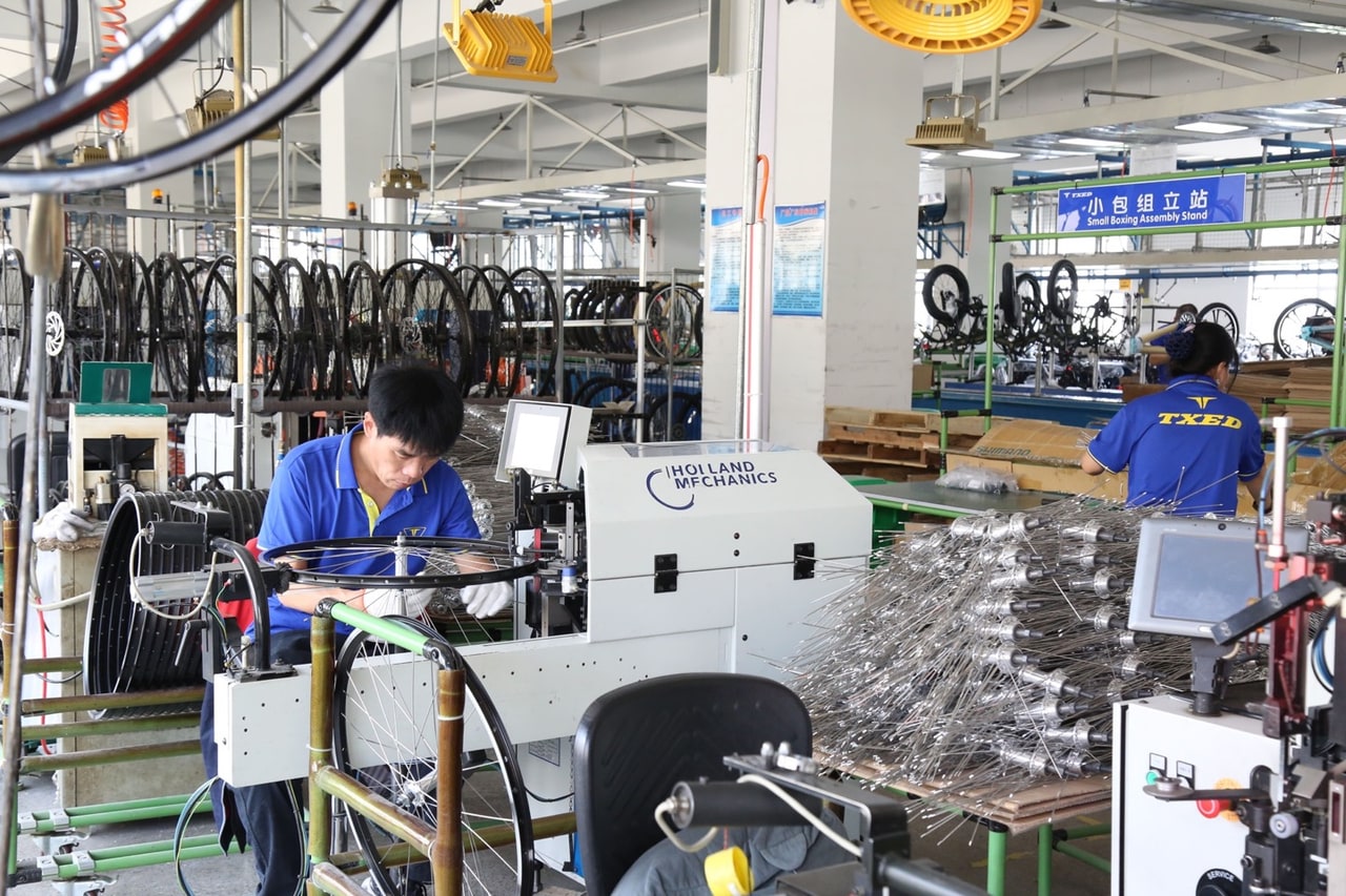 Row of e-bikes in a factory line being prepared for OEM branding and white-label shipment